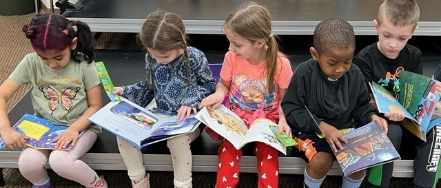 MCES students looking at their new book!