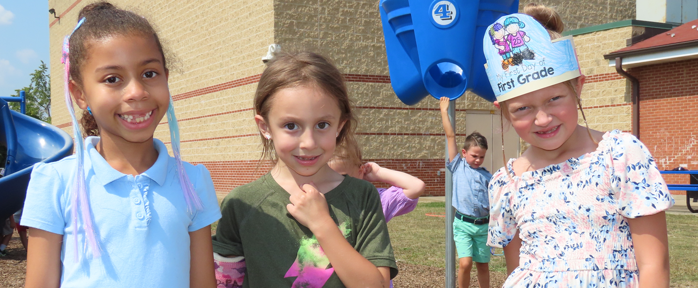 Students smile on the playground on the first day of school