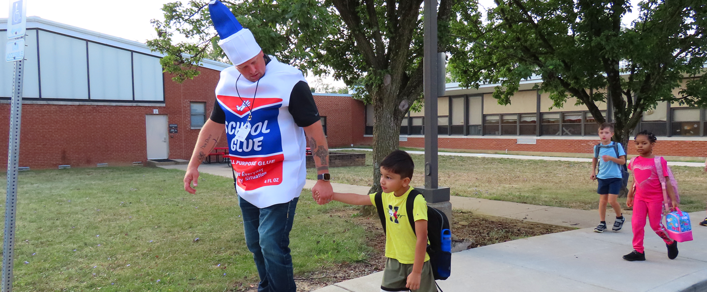 Principal Zunic walks a student into school on the first day of school